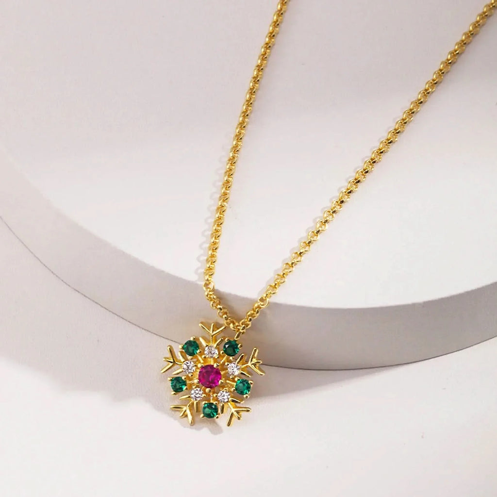 A gold necklace elegantly displayed on a white stand, featuring a sunburst pendant with multicolored gemstones at the center and a large, solitary pearl. The chain is simple, ensuring that the focus remains on the intricate design of the pendant and the pearl, signifying a blend of modern luxury and classic beauty.