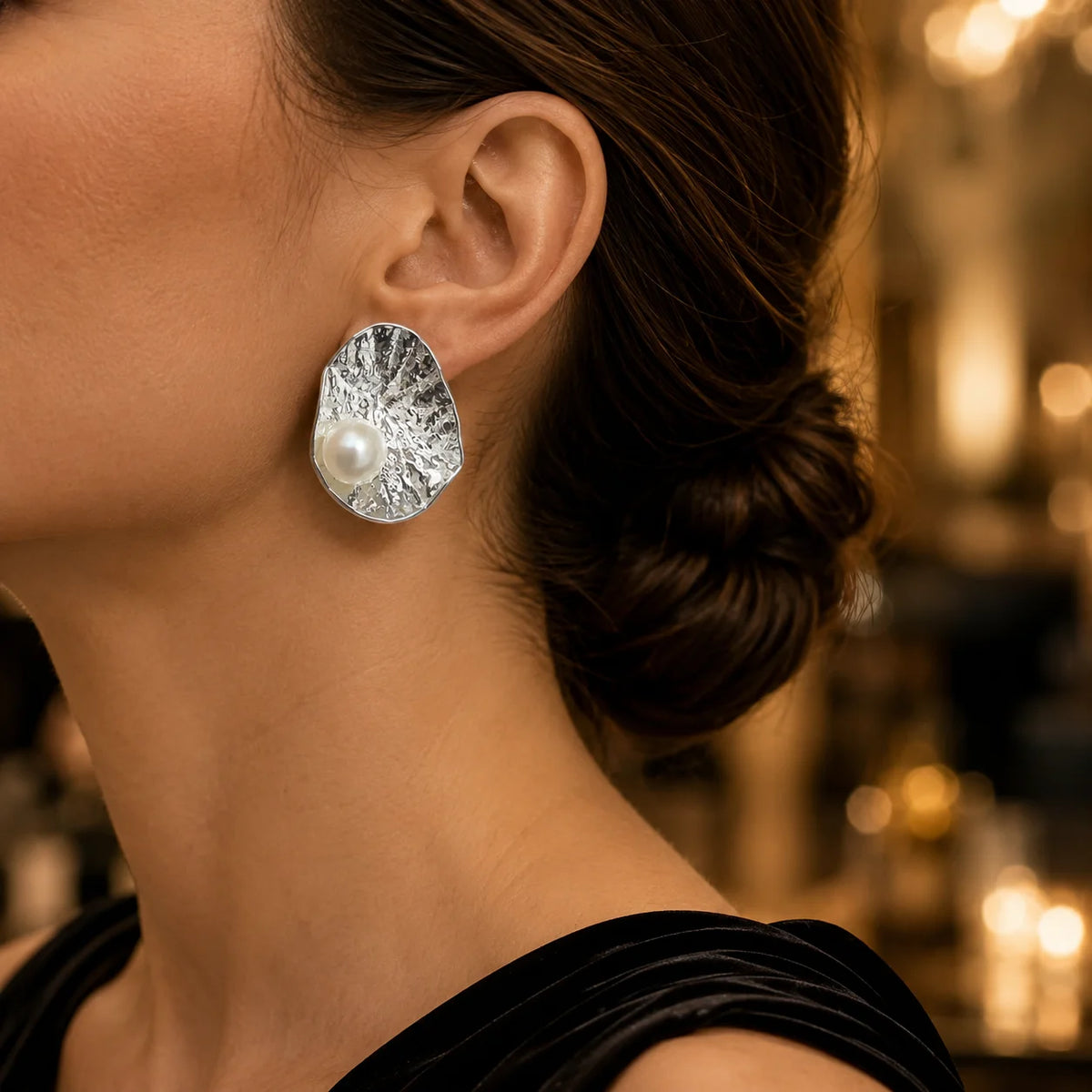 Model wearing silver-tone hammered freshwater pearl statement stud earrings