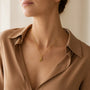 Model wearing gold-tone sterling silver feather pendant necklace