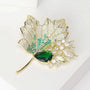 Close-up of green pear-shaped crystal, pavé leaf veins and marquise crystal accents on a maple leaf brooch