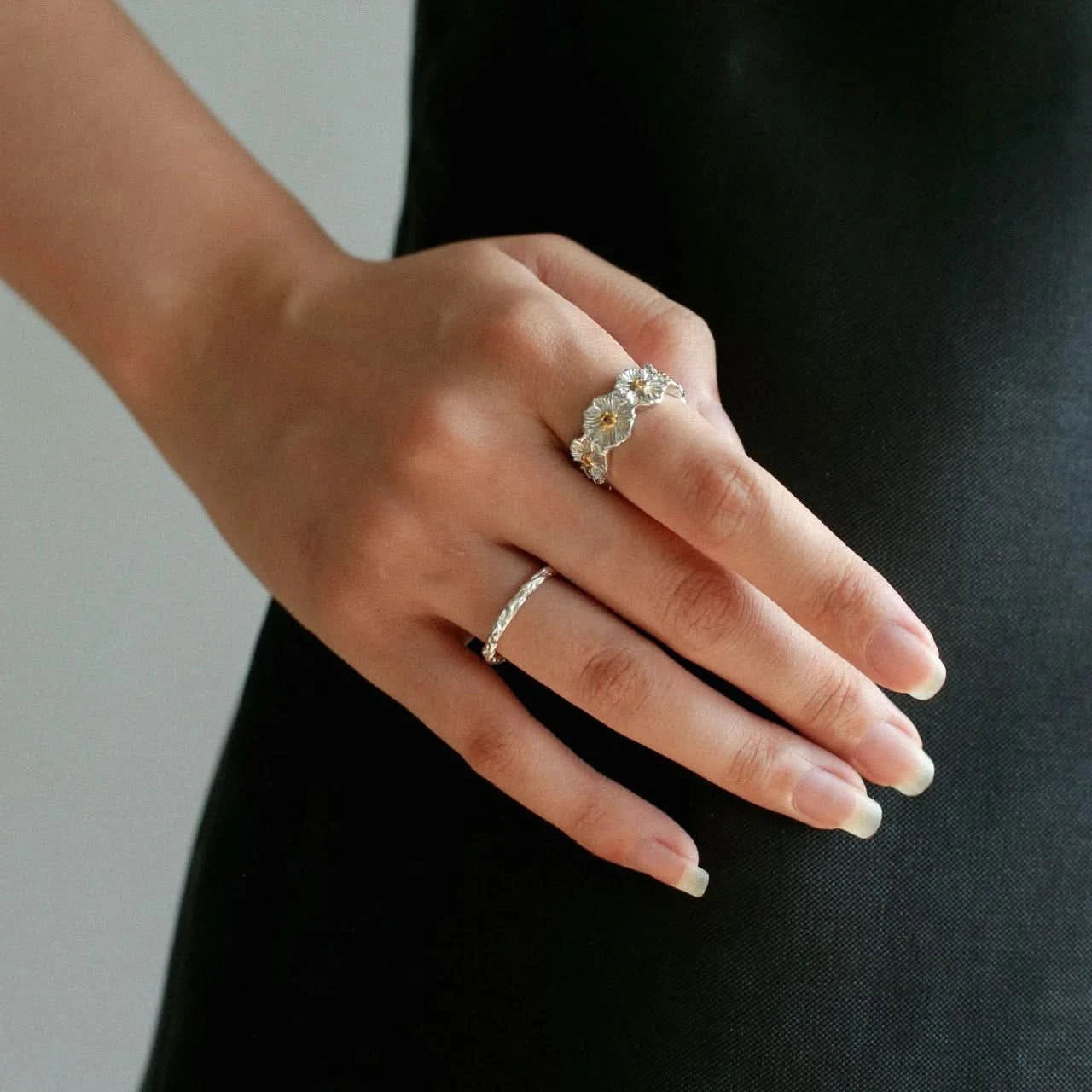 Hand wearing two silver rings 