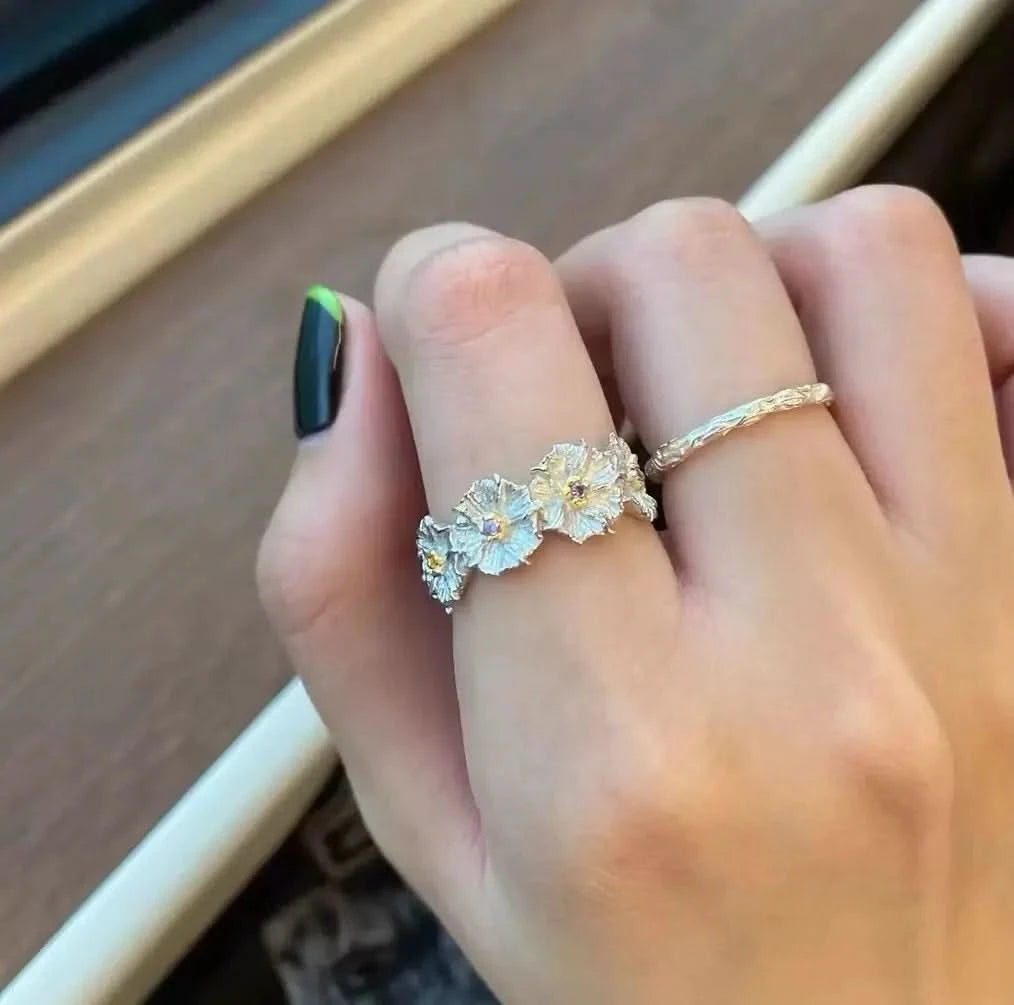 Hand wearing a floral silver ring 