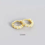 Gold hoop earrings with small diamonds on a gray background