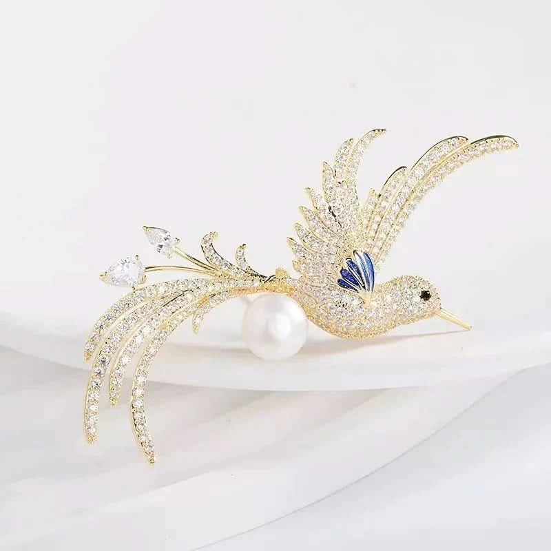 Crystal bird brooch with clear feather details, deep blue enamel wing and pearl-effect accent