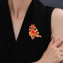 Goldfish brooch with amber-orange crystal body worn as a statement accessory on a black blazer