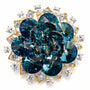 Teal crystal layered flower brooch on a white background