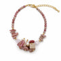 Pink rhodonite rose quartz and pearl cluster bracelet on a white background