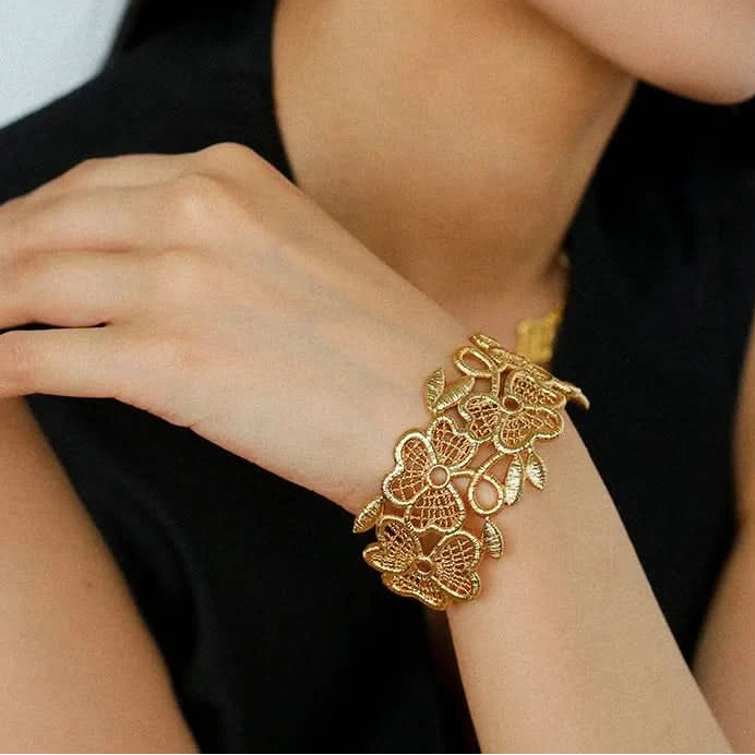 Gold bracelet on a person's wrist with a blurred background