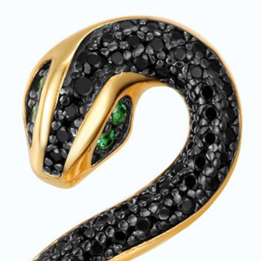 A pair of luxurious gold and black snake earrings, each set with a row of black crystals along the snake's body and featuring vibrant green crystal eyes. The design is anchored by a large white pearl at the bottom, creating a bold and elegant statement piece.