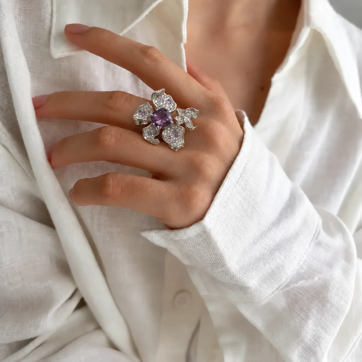 Woman wearing a purple floral zircon sterling silver statement ring