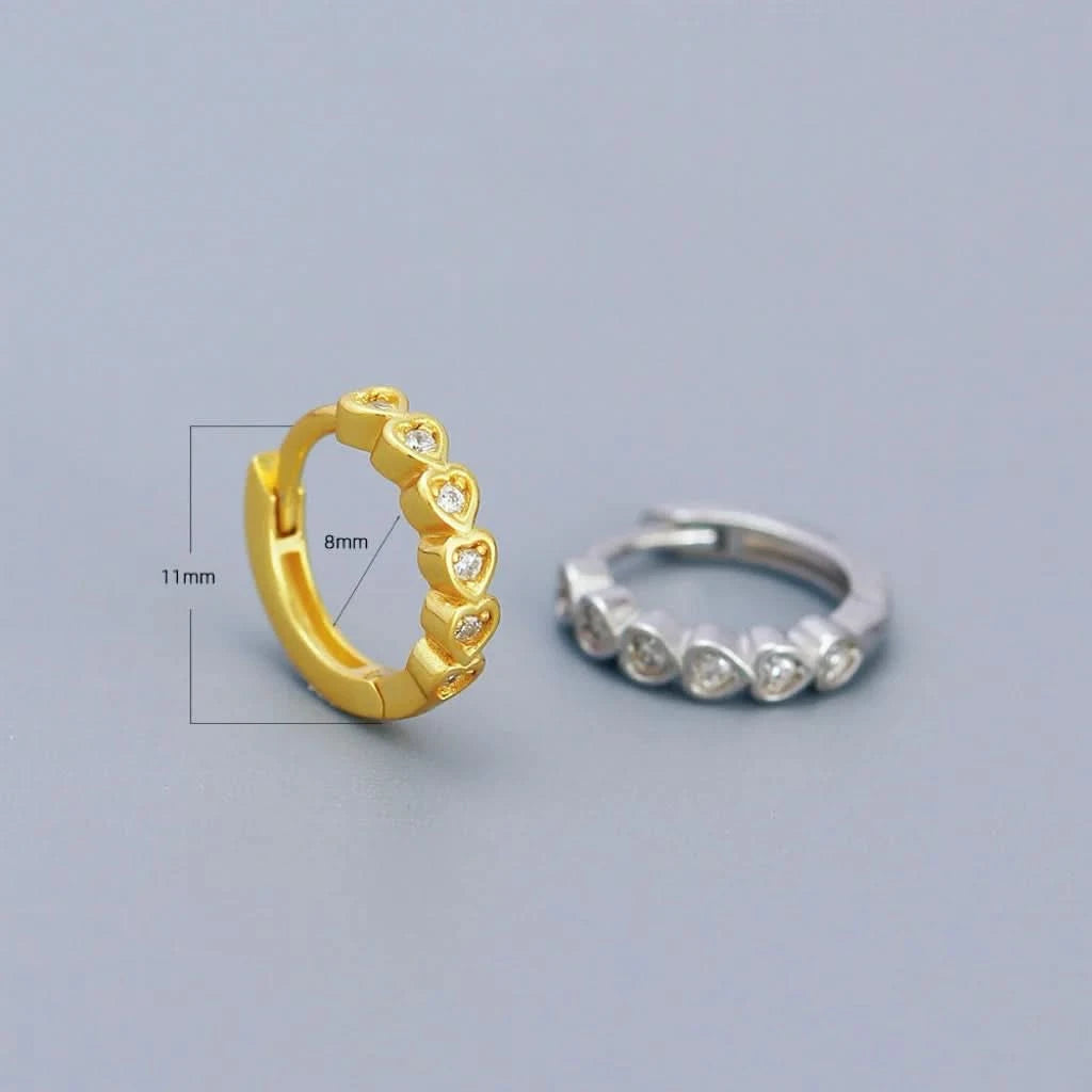 Gold and silver hoop earrings on a light gray background
