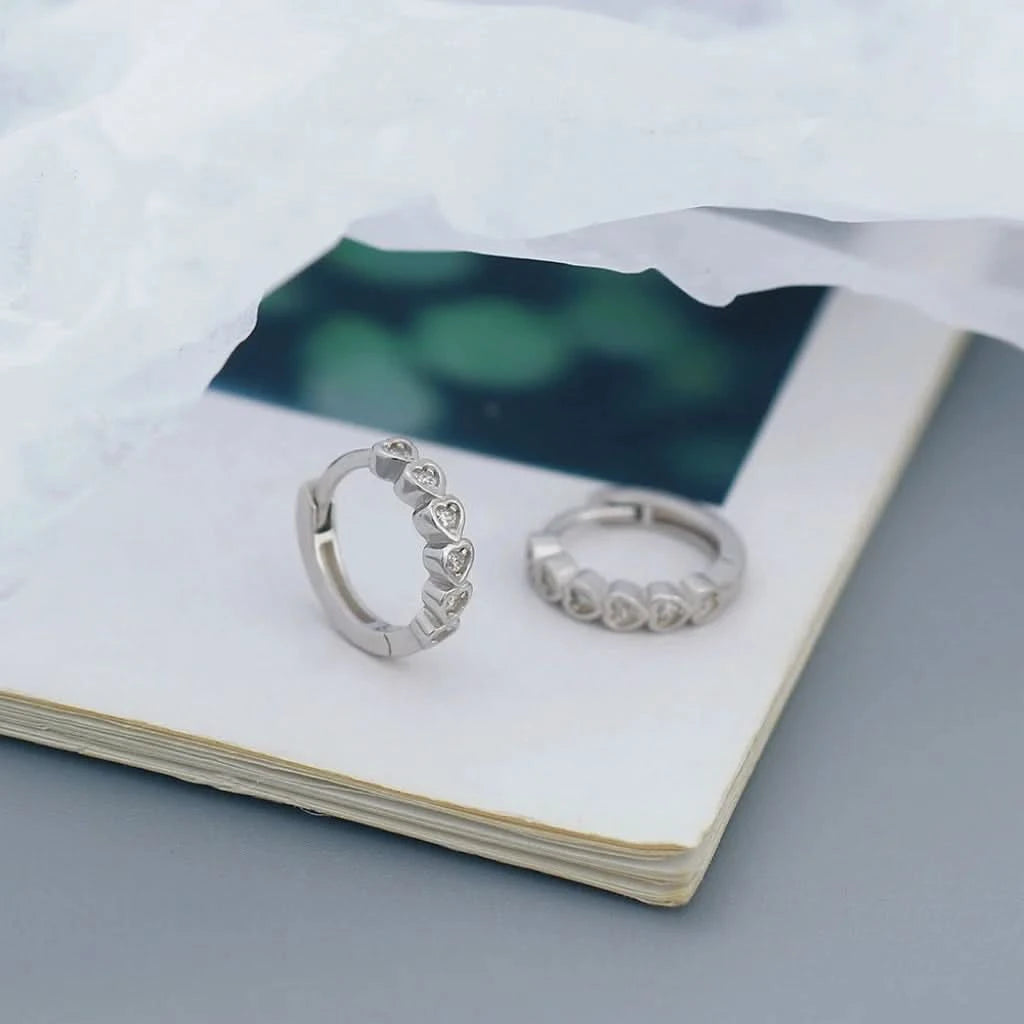 Two silver rings on a white surface with a blurred green background
