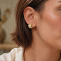 Model wearing gold-tone molten organic freshwater pearl stud earrings