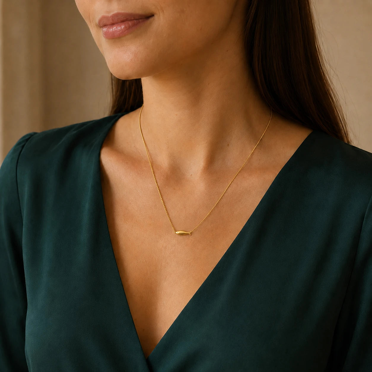 Model wearing minimalist gold-tone necklace with a smooth horizontal fish centrepiece