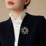 Teal heart crystal vine brooch worn on a navy blazer