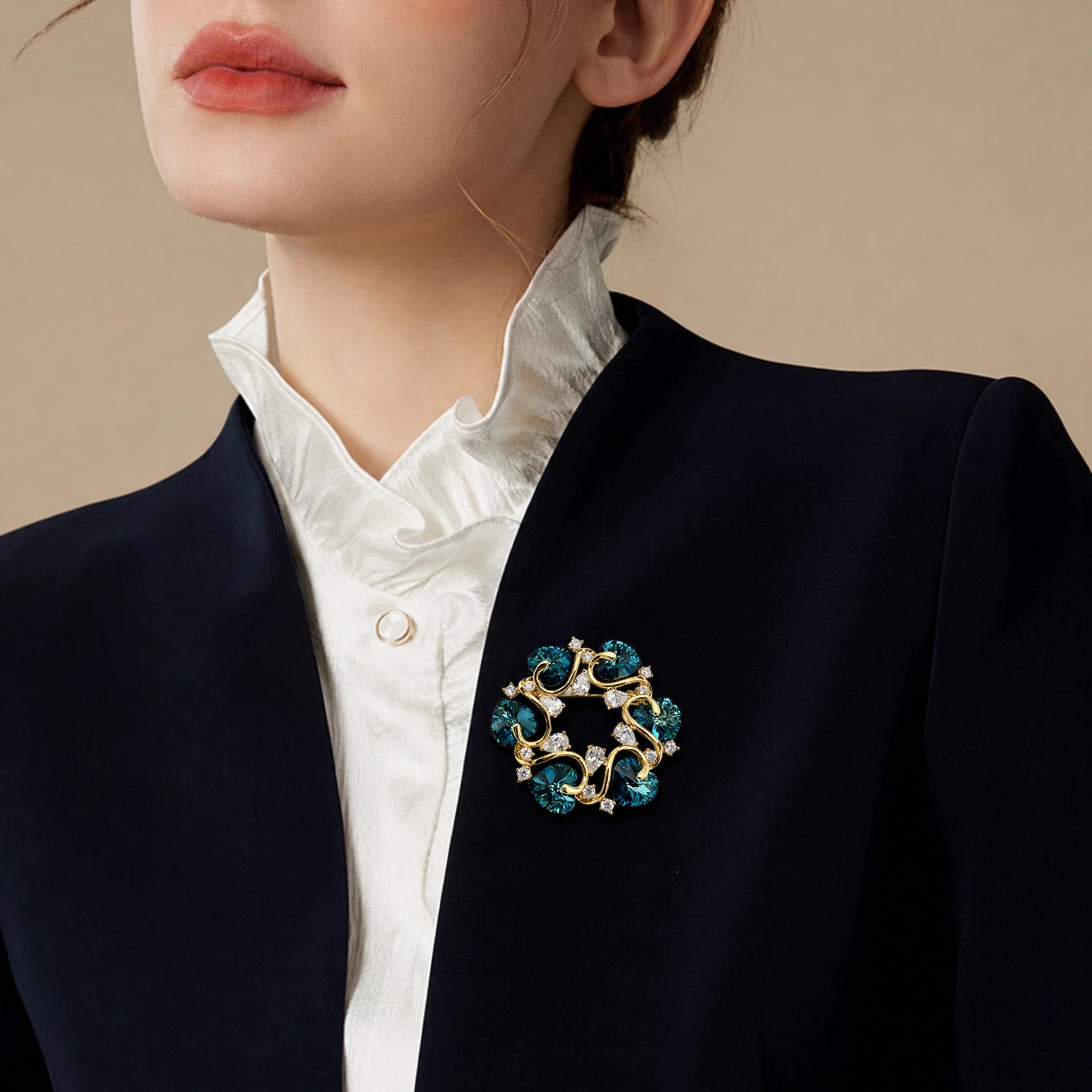 Teal heart crystal vine brooch worn on a navy blazer