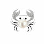 Silver-tone pearl crab brooch with cubic zirconia claws and black eyes on a white background