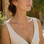 Pink tourmaline and sunstone teardrop necklace with freshwater pearl accents worn outdoors
