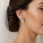Bride wearing silver-tone freshwater pearl crystal laurel stud earrings
