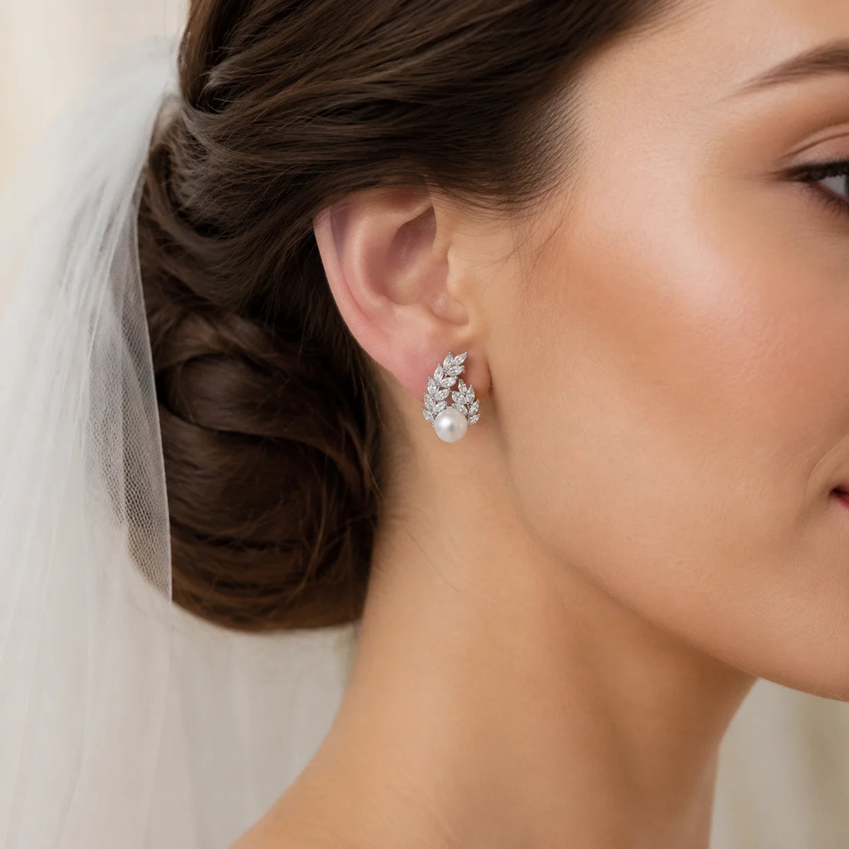 Bride wearing silver-tone freshwater pearl crystal laurel stud earrings