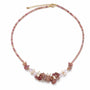 Pink gemstone rose quartz and freshwater pearl cluster necklace on a white background