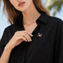 Gold-tone pearl crab brooch with cubic zirconia claws worn on a black blouse