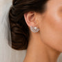 Bride wearing silver-tone freshwater pearl ginkgo leaf stud earrings with clear zircon details