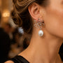 Model wearing silver flower baroque pearl drop earrings