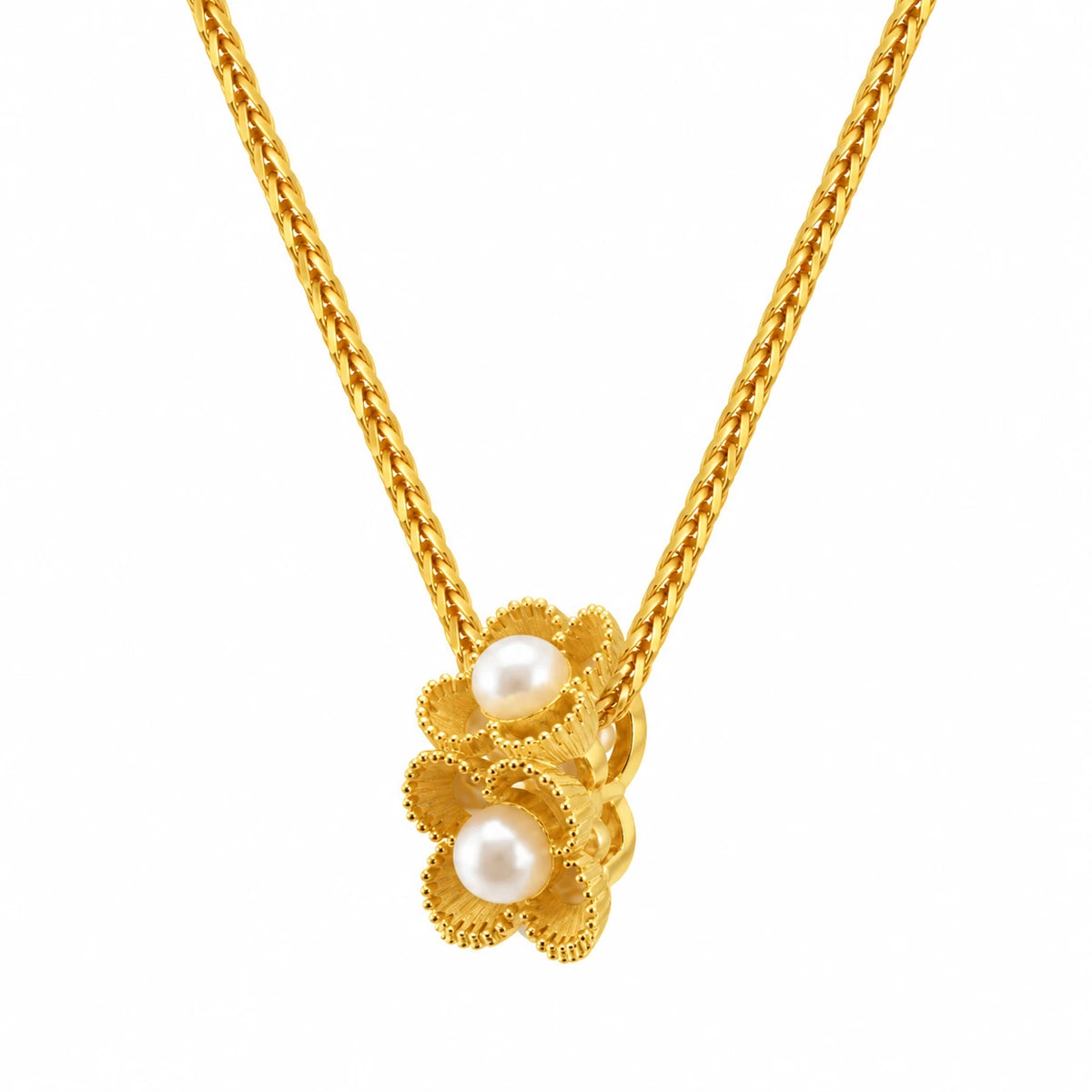 Close-up of two stacked gold-tone flowers with beaded petals and pearl-style centres