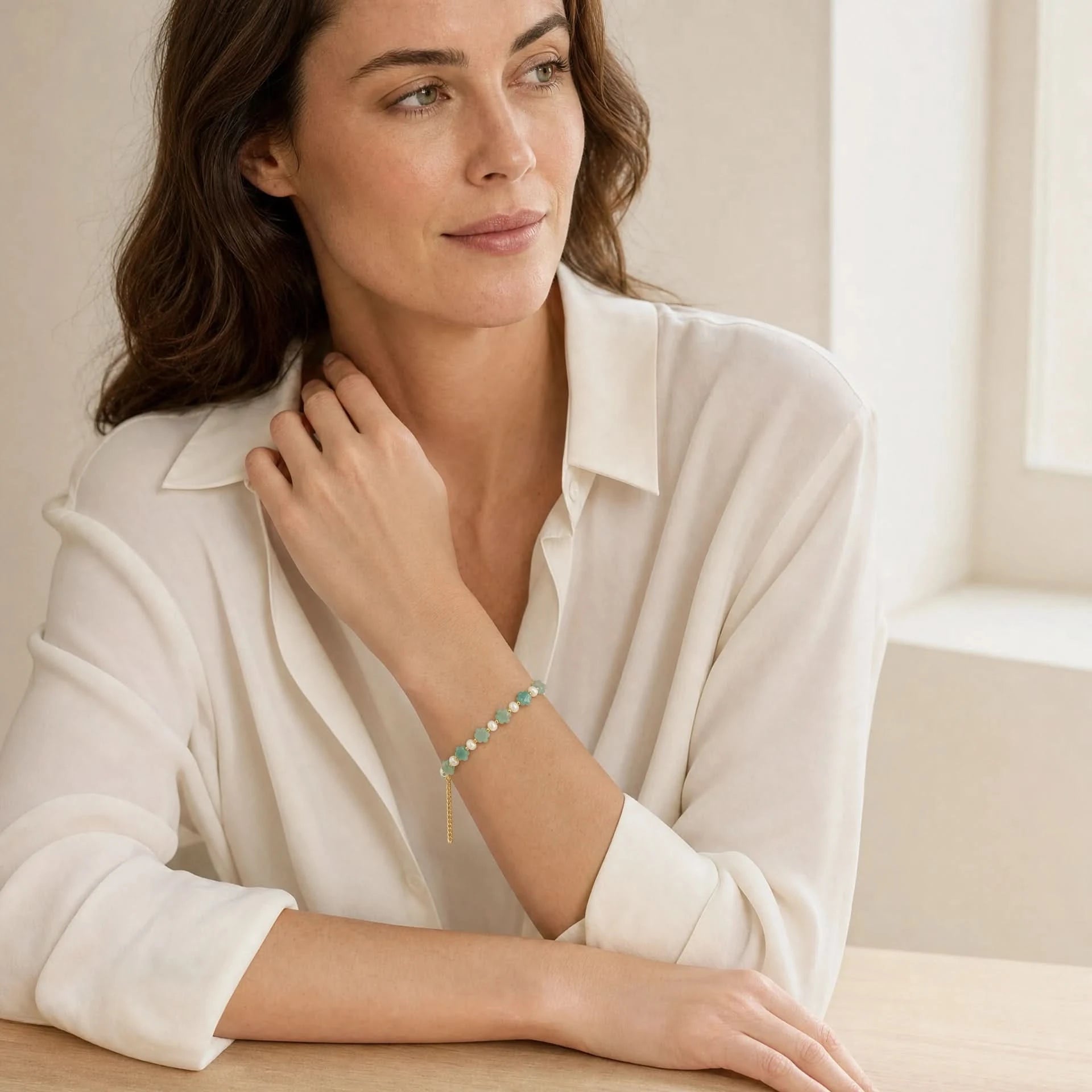 Amazonite flower and freshwater pearl bracelet with gold-tone spacers worn indoors