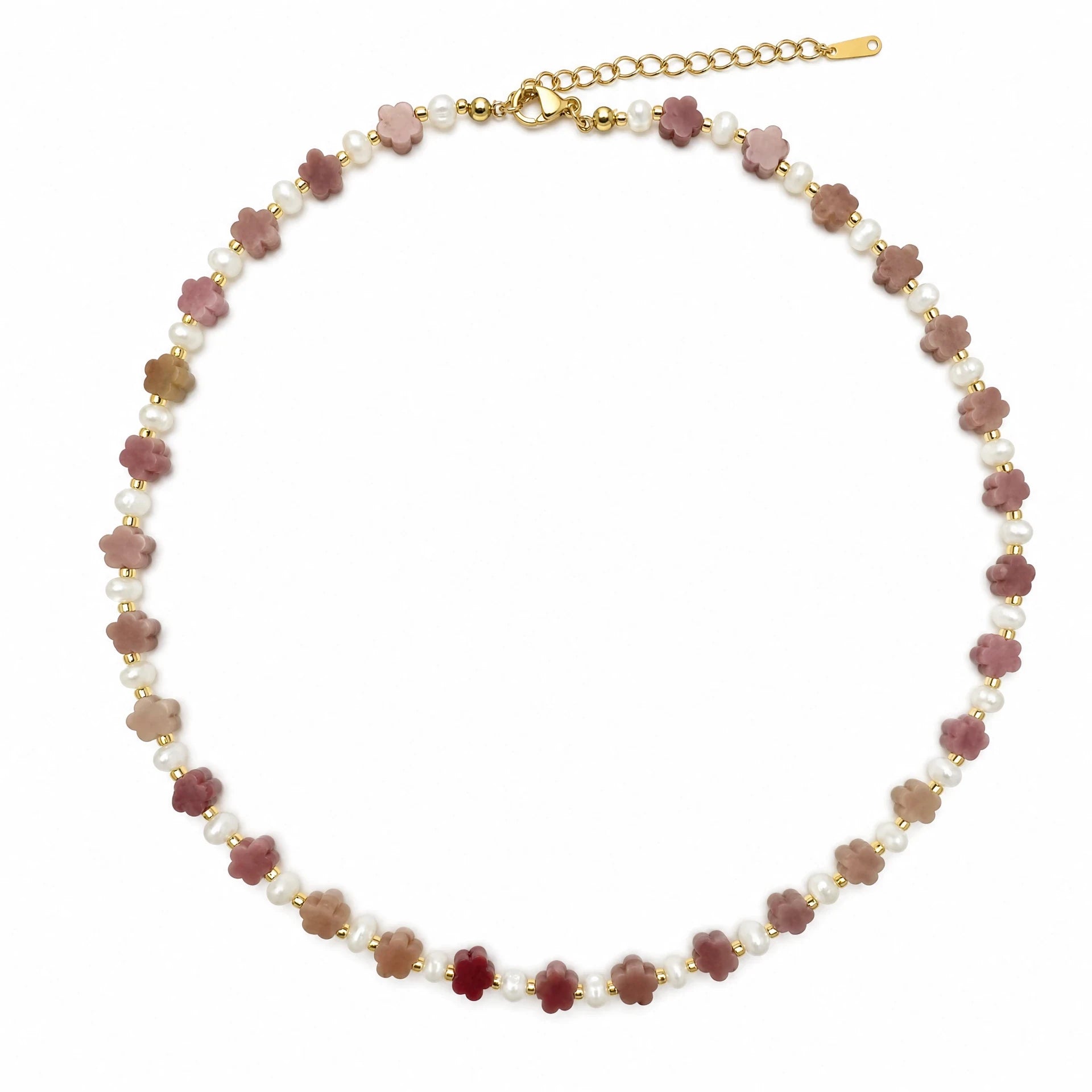 Carved rhodochrosite flower and white stone beaded necklace with gold-tone details on a white background