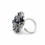 Side view of raised blue and clear zirconia flower ring with adjustable open band