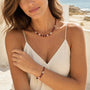 Red agate and freshwater pearl necklace worn with matching bracelet on a beach