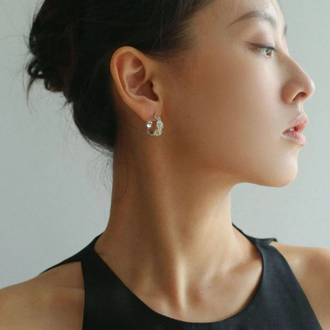 Close-up of a woman wearing a hoop earring 