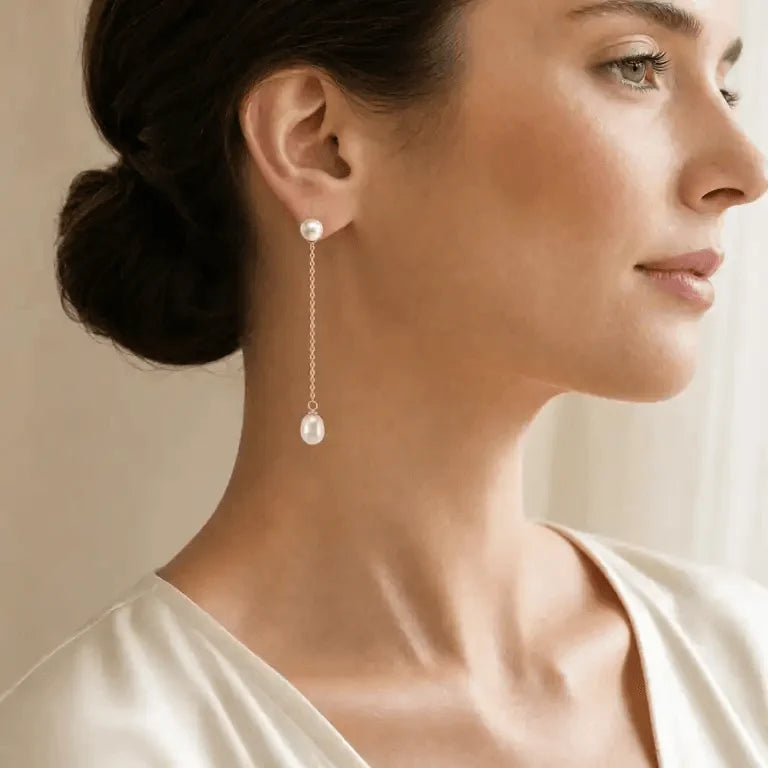 Model wearing freshwater pearl chain drop stud earrings with oval pearl drops