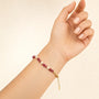 Rhodonite and mother-of-pearl beaded bracelet with gold-tone spacers worn on the wrist
