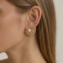 Model wearing gold-tone freshwater pearl ginkgo leaf stud earrings with clear zircon details