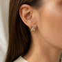 Model wearing gold-tone freshwater pearl butterfly stud earrings with clear crystal accents