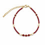 Red agate and freshwater pearl beaded bracelet on a white background