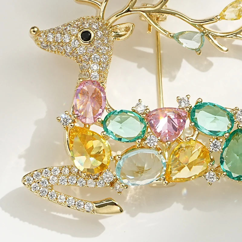 Close-up of pink green blue and yellow crystals on a gold-tone deer brooch