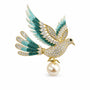 Teal crystal peace dove brooch with gradient wings and suspended Swarovski pearl on a white background