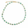 Carved amazonite flower and white stone beaded necklace with gold-tone details on a white background