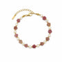 Rhodochrosite flower and freshwater pearl bracelet with gold-tone spacers on a white background