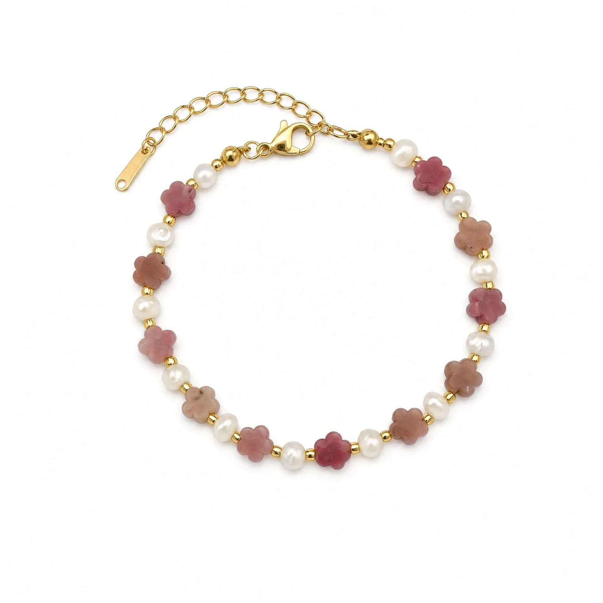 Rhodochrosite flower and freshwater pearl bracelet with gold-tone spacers on a white background