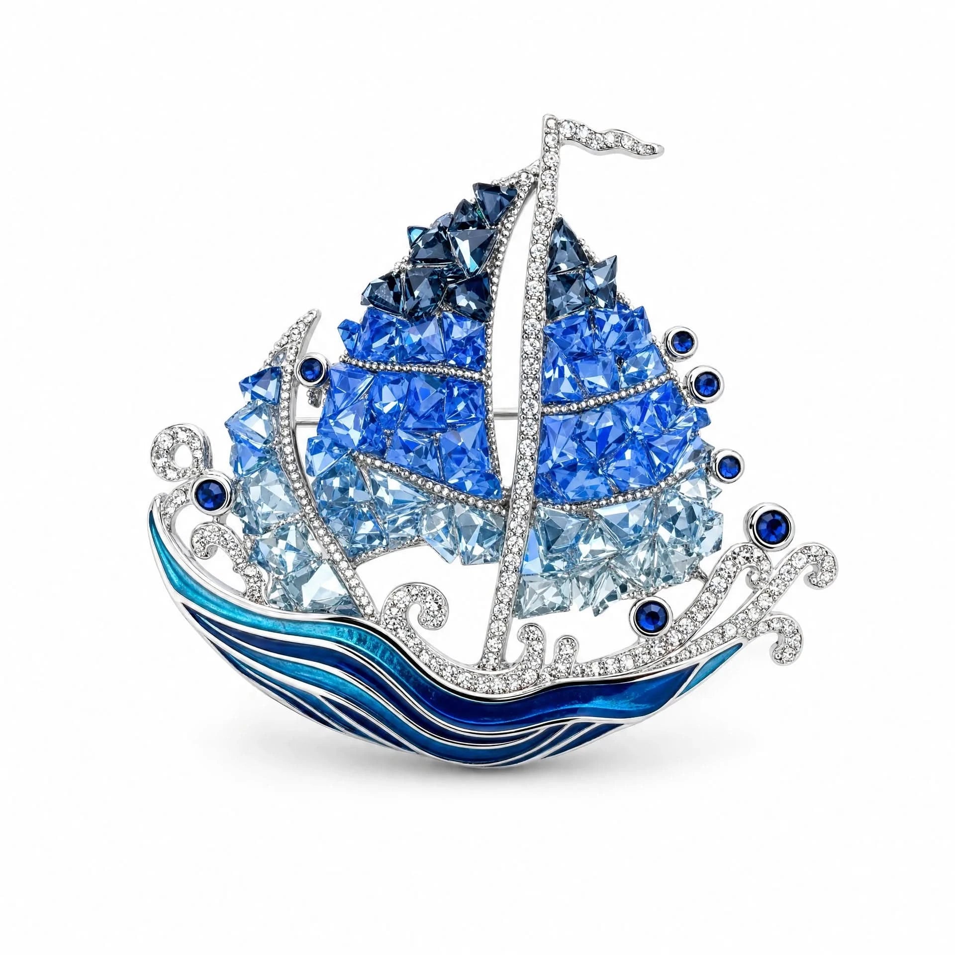 Blue crystal sailing ship brooch with silver-tone mast and enamel ocean waves on a white background