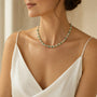 Carved amazonite flower and white stone beaded necklace worn at a three quarter angle