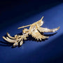 Back view of gold-tone crystal bird brooch showing secure pin fastening and feathered tail