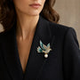 Teal crystal peace dove brooch with Swarovski pearl worn on a black blazer lapel