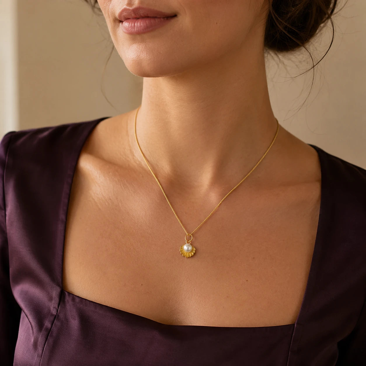 Model wearing gold-tone scallop shell pearl pendant necklace