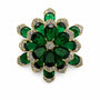 Layered flower brooch with emerald-green crystal petals and clear crystal borders on a white background